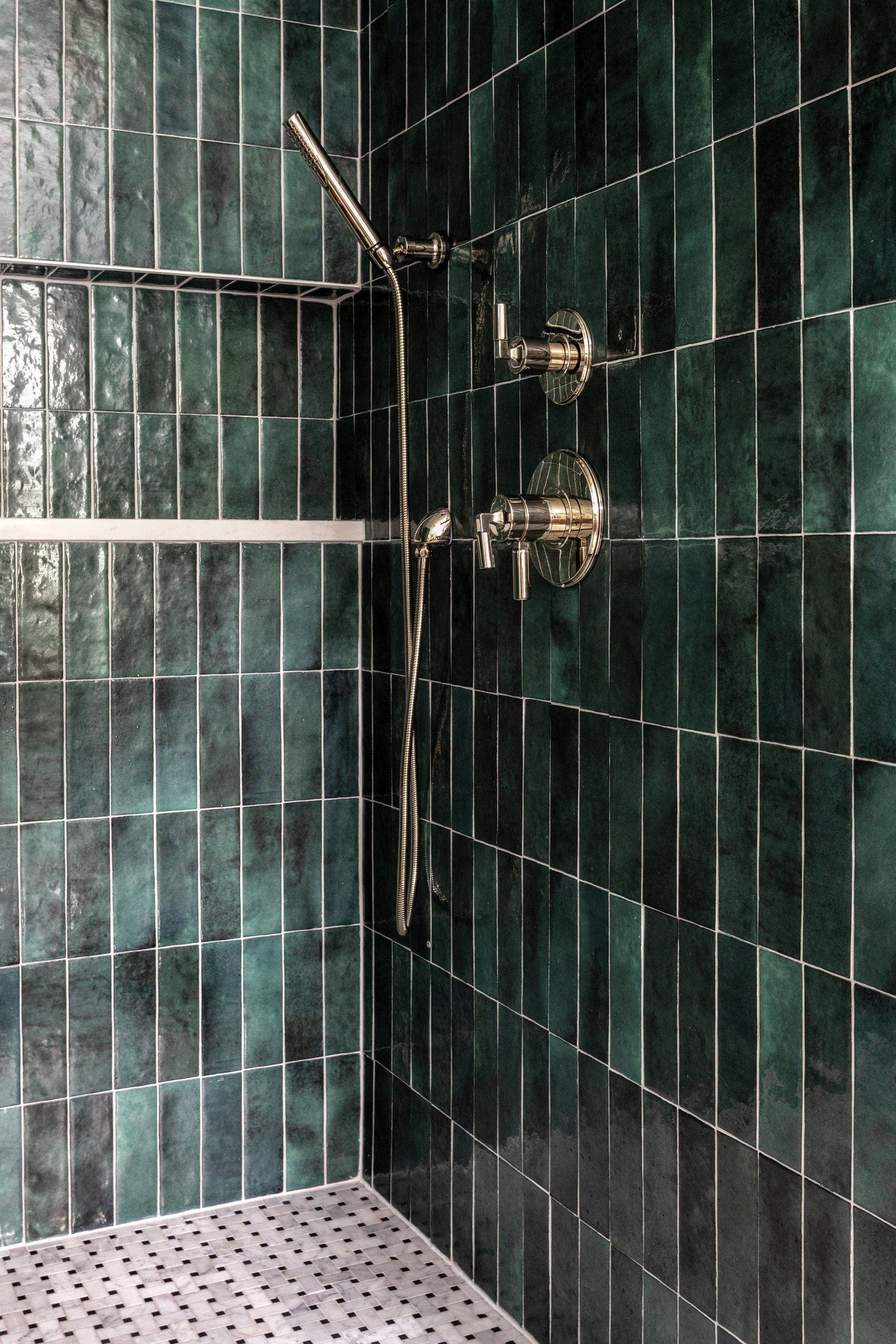 Side-by-side bathroom showers featuring glossy green rectangular tile.
